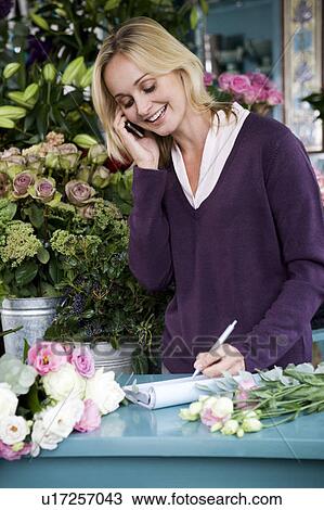 Woman florist taking an order over the telephone View Large Photo Image Stock Image - Woman florist taking an order over the telephone. Fotosearch