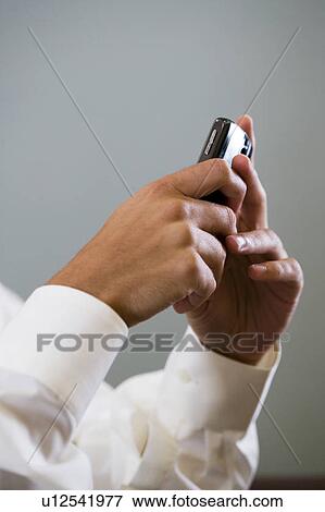 Close up of a man using a mobile phone to SMS test message View Large Photo Image Stock Photo - Close up of a man using a mobile phone to SMS test message. Fotosearch