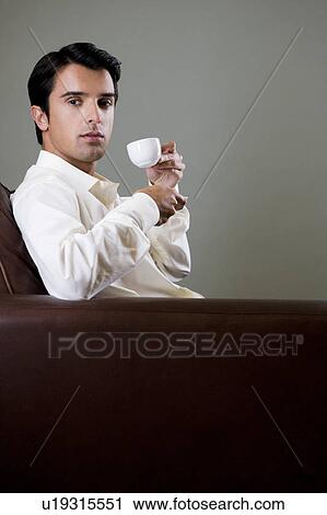 Stock Image - Portrait of a man drinking from an espresso cup. Fotosearch