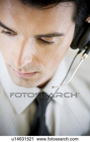 Portrait of a man using a call centre headset View Large Photo Image Stock Image - Portrait of a man using a call centre headset. Fotosearch