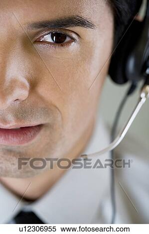 Stock Photography - Portrait of a man using a call centre headset. Fotosearch