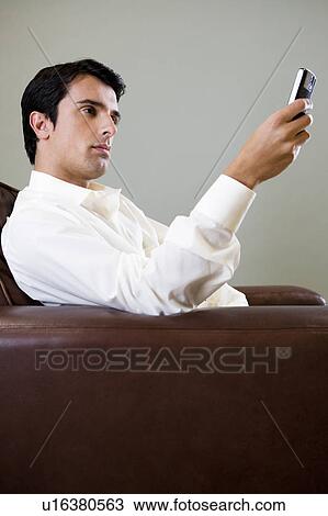 Portrait of a man using a cellphone to SMS text message View Large Photo Image Stock Image - Portrait of a man using a cellphone to SMS text message. Fotosearch