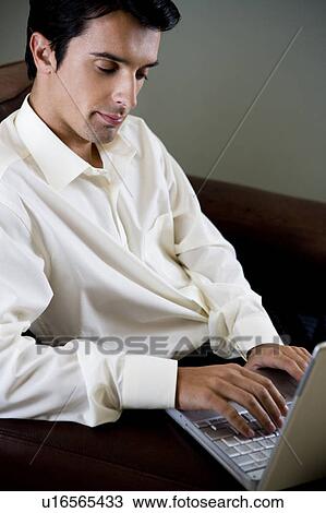 Stock Image - Portrait of a man using a laptop computer. Fotosearch