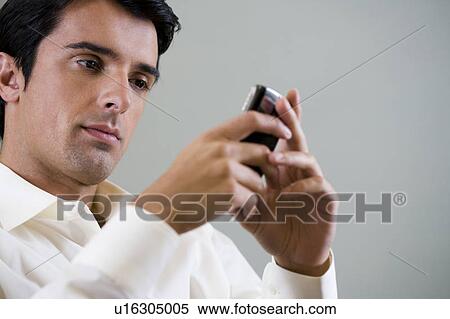 Stock Photography - Portrait of a man using a mobile phone to SMS test message. Fotosearch