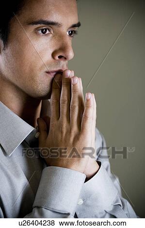 Stock Photo - Portrait of a man with his hands in a praying position . Fotosearch