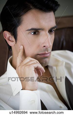 Portrait of a young man looking pensive View Large Photo Image Picture - Portrait of a young man looking pensive. Fotosearch