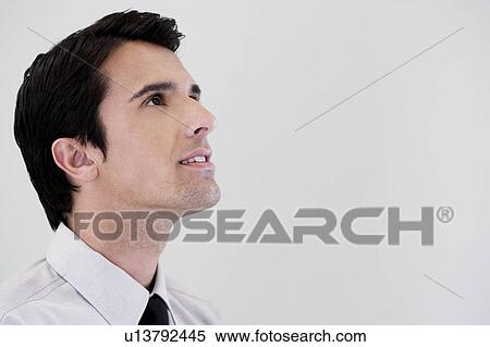 Stock Photography - Side profile portrait of a businessman looking happy. Fotosearch