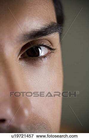 Stock Photo - Close up of a young man's face focusing on the eye. Fotosearch