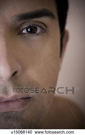 Stock Image - Close up of a young man's face, focusing on the eye. Fotosearch