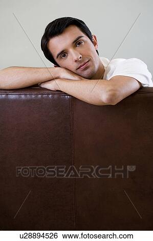 Portrait of a man relaxing in an armchair View Large Photo Image Stock Photograph - Portrait of a man relaxing in an armchair. Fotosearch