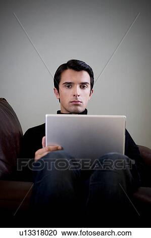 Stock Image - Portrait of a man using a laptop computer. Fotosearch