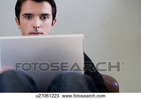 Portrait of a man using a laptop computer View Large Photo Image Stock Image - Portrait of a man using a laptop computer. Fotosearch