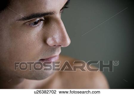 Stock Image - Portrait of a young man looking pensive. Fotosearch