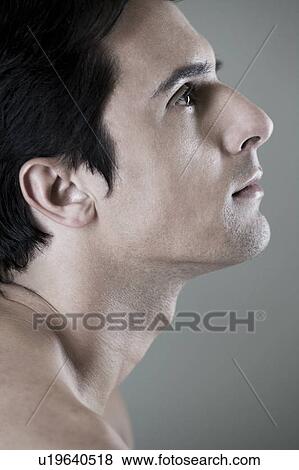 Portrait of a young man looking upwards View Large Photo Image Stock Photo - Portrait of a young man looking upwards. Fotosearch