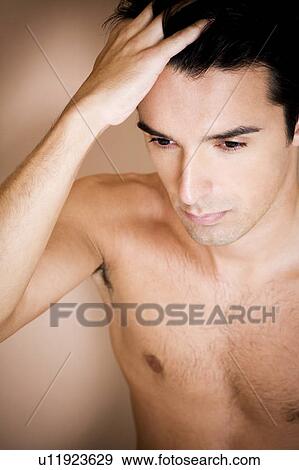 Stock Photo - Portrait of a young man running his fingers through his hair. Fotosearch