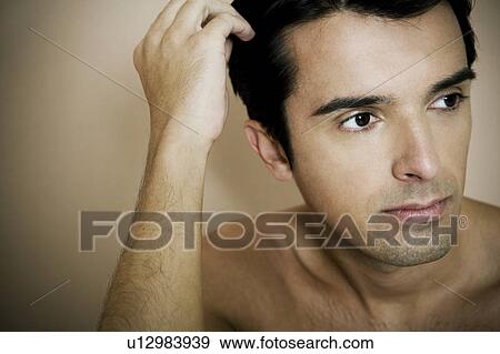 Portrait of a young man running his fingers through his hair View Large Photo Image Stock Photo - Portrait of a young man running his fingers through his hair. Fotosearch