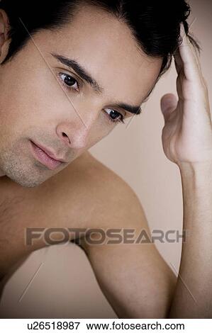 Portrait of a young man running his fingers through his hair View Large Photo Image Stock Photo - Portrait of a young man running his fingers through his hair. Fotosearch