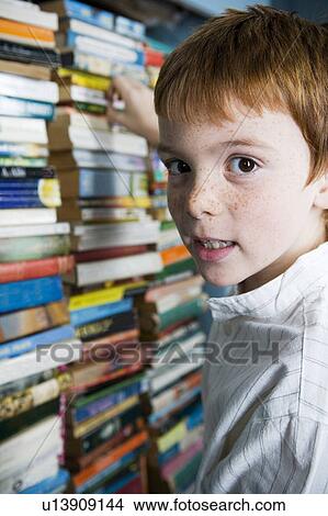 boy choosing book from bookshelf View Large Photo Image Picture - boy choosing book from bookshelf. Fotosearch