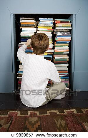 boy choosing book from bookshelf View Large Photo Image Stock Photo - boy choosing book from bookshelf. Fotosearch