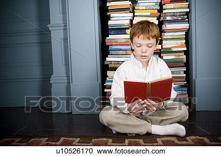 boy reading book sitting on the floor View Large Photo Image Stock Image - boy reading book sitting on the floor. Fotosearch
