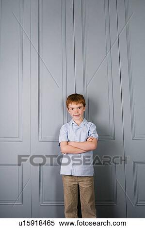 boy standing against very tall door View Large Photo Image Stock Photography - boy standing against very tall door. Fotosearch