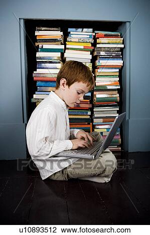 Stock Image - boy with laptop sitting on the floor. Fotosearch