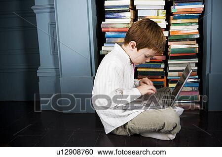 Stock Image - boy with laptop sitting on the floor. Fotosearch