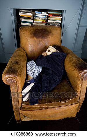 Stock Photo - little boy curled up asleep in armchair. Fotosearch