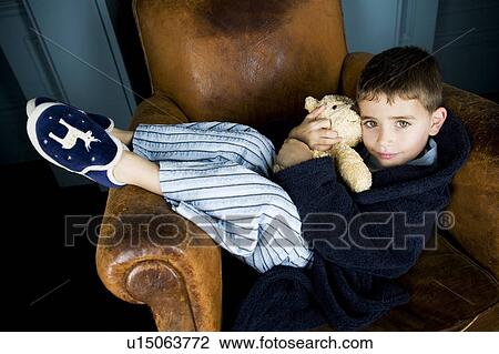 little boy getting cosy in armchair with teddy bear View Large Photo Image Stock Image - little boy getting cosy in armchair with teddy bear. Fotosearch
