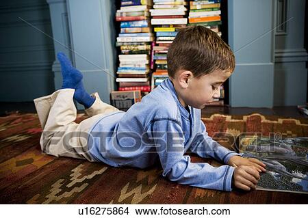 little boy reading picture book lying on the floor View Large Photo Image Picture - little boy reading picture book lying on the floor. Fotosearch