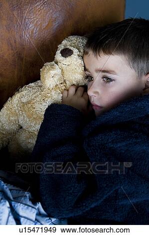 Stock Photo - little boy snuggling up with teddy bear. Fotosearch