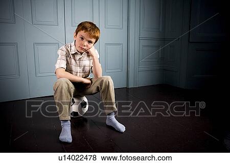 Stock Photo - sad little boy sitting on his football. Fotosearch