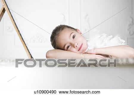 Stock Image - Portrait of a young girl with a feather boa in dressing up clothes. Fotosearch