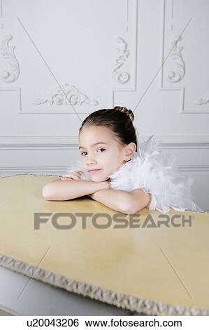 Stock Photograph - Portrait of a young girl with a feather boa in dressing up clothes. Fotosearch