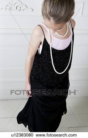 Stock Image - Young girl playing at dressing up . Fotosearch