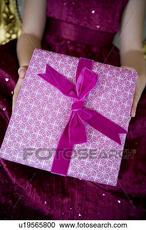 Stock Image - Close up a little girl holding a birthday present . Fotosearch