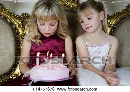Little girl and friend holding a birthday cake with lit candles View Large Photo Image Stock Photo - Little girl and friend holding a birthday cake with lit candles. Fotosearch