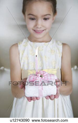 Little girl holding a birthday cake with lit candles View Large Photo Image Stock Image - Little girl holding a birthday cake with lit candles. Fotosearch