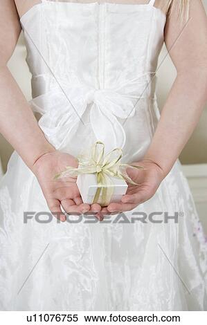 Little girl holding a present behind her back, close up View Large Photo Image Stock Photography - Little girl holding a present behind her back, close up. Fotosearch