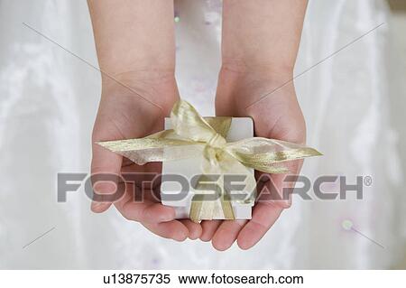 Little girl holding a present, close up View Large Photo Image Stock Photography - Little girl holding a present, close up. Fotosearch