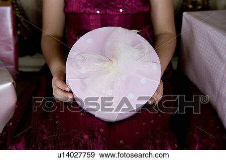 Stock Photo - Little girl holding birthday presents . Fotosearch