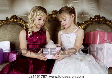 Stock Photo - Little girls sharing birthday presents. Fotosearch