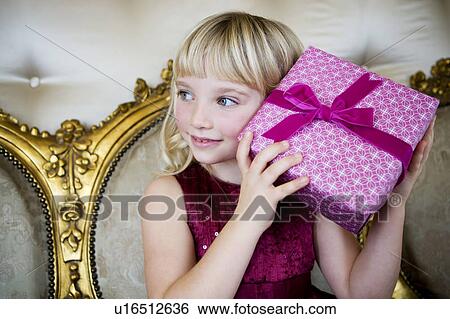 Portrait of a little girl trying to guess her birthday presents View Large Photo Image Stock Photograph - Portrait of a little girl trying to guess her birthday presents. Fotosearch