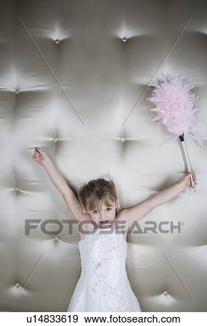 Little girl in a party dress holding a pink feather duster View Large Photo Image Stock Photo - Little girl in a party dress holding a pink feather duster . Fotosearch