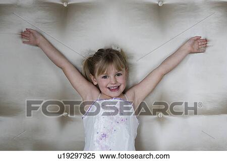 Stock Photography - Little girl in a party dress with arms outstretched . Fotosearch
