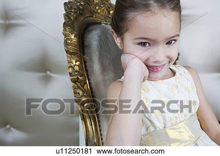 Little girl sitting in an ornate chair wearing a party dress View Large Photo Image Stock Image - Little girl sitting in an ornate chair wearing a party dress. Fotosearch