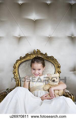 Little girl sitting in an ornate chair wearing a party dress holding a teddy bear View Large Photo Image Stock Image - Little girl sitting in an ornate chair wearing a party dress holding a teddy bear. Fotosearch