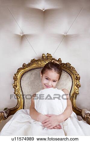 Little girl sitting in an ornate chair wearing a party dress View Large Photo Image Stock Photo - Little girl sitting in an ornate chair wearing a party dress. Fotosearch