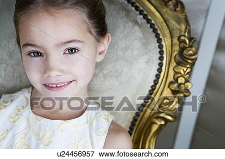 Little girl sitting in an ornate chair wearing a party dress View Large Photo Image Stock Photo - Little girl sitting in an ornate chair wearing a party dress. Fotosearch