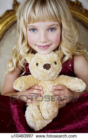 Portrait of a little girl holding a teddy bear View Large Photo Image Stock Photo - Portrait of a little girl holding a teddy bear. Fotosearch